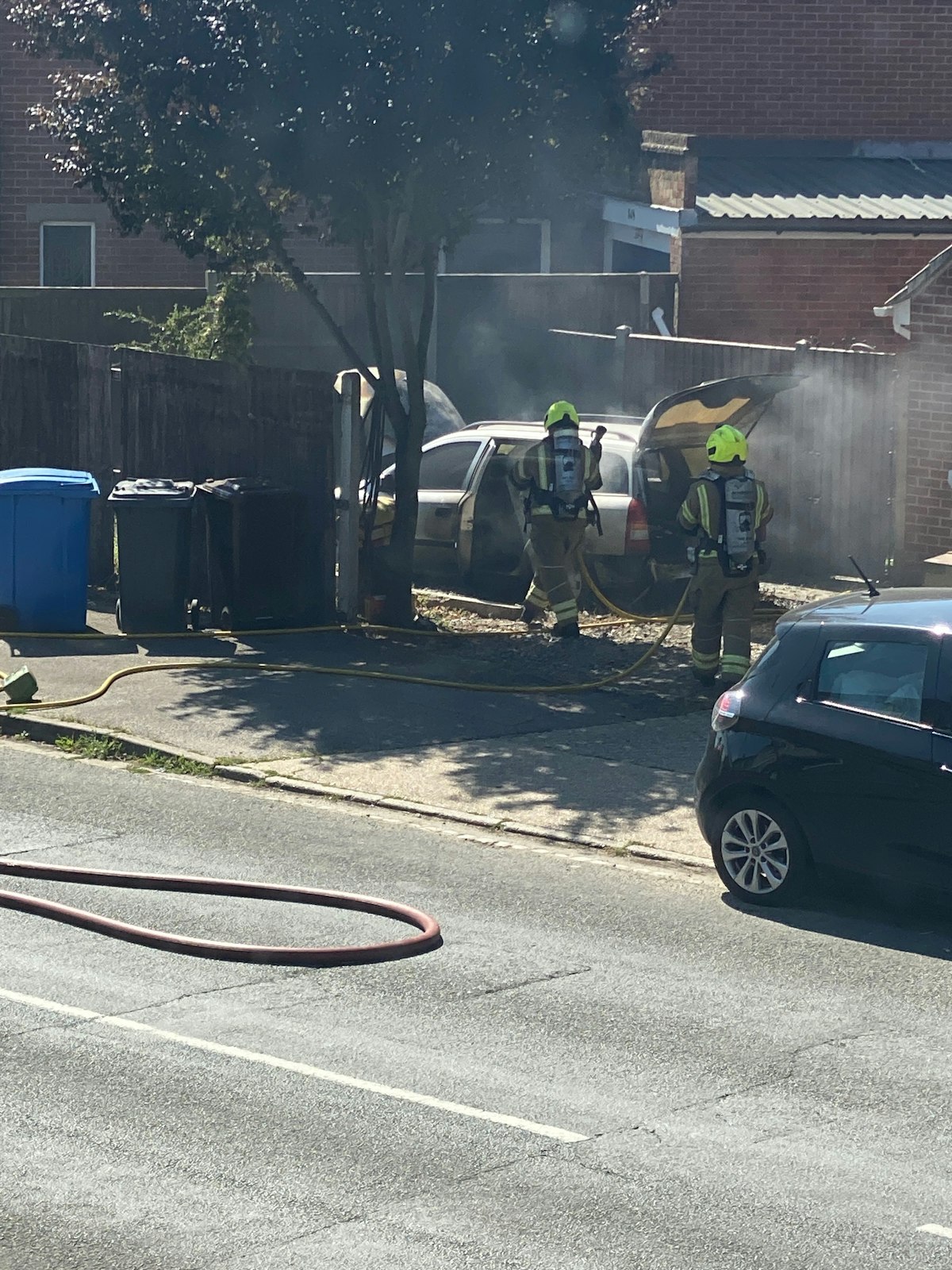 Firefighters tackle a car fire